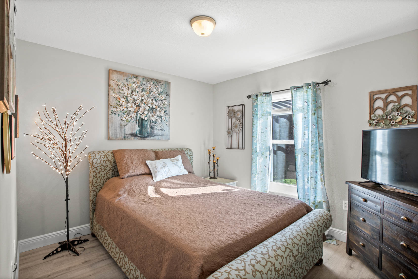 bedroom with brown comforter and brown and beige decor with window